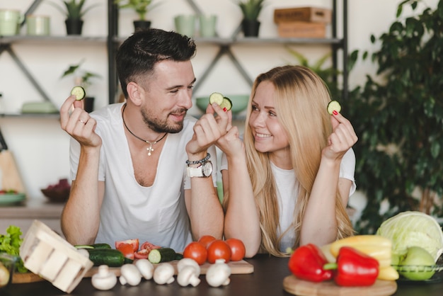 Uśmiechnięci potomstwa dobierają się mienie ogórkowego plasterek patrzeje each inny