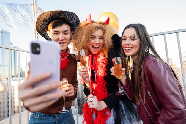 Uśmiechnięci przyjaciele ze średnim ujęciem robiący selfie