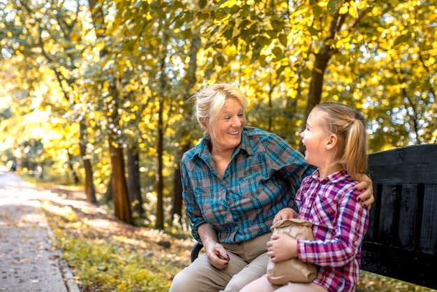 Uśmiechnięta babcia przytulanie jej wnuka w parku