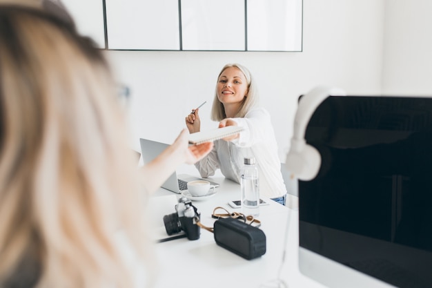 Uśmiechnięta Blond Sekretarka Wręczyła Koledze Dokumenty I Popijała Kawę