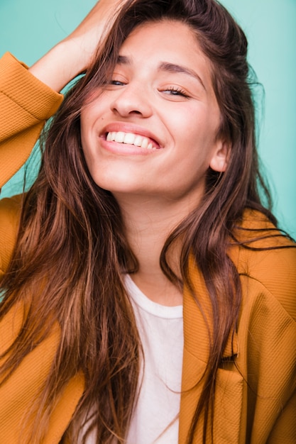 Bezpłatne zdjęcie uśmiechnięta brunetki dziewczyna pozuje z żakietem