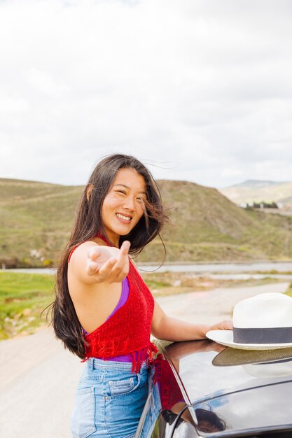 Uśmiechnięta chińska młoda kobieta oferuje podążać za nią w naturze