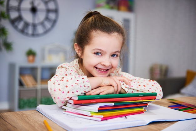 Bezpłatne zdjęcie uśmiechnięta dziewczyna studiuje w domu