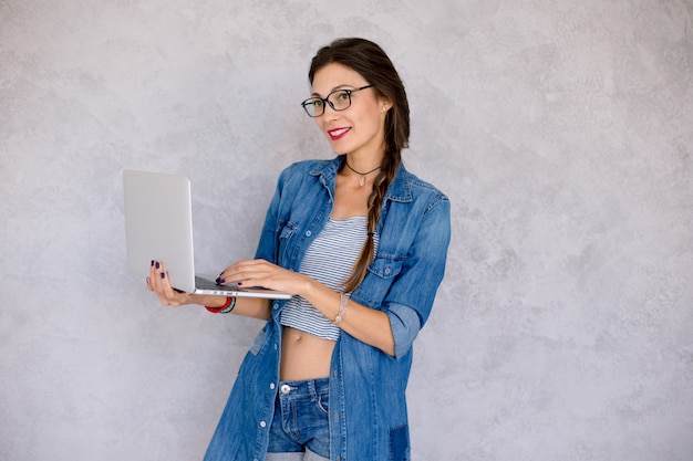 Uśmiechnięta kobieta pisać na maszynie na laptopie