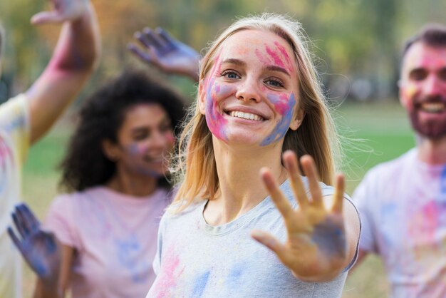 Uśmiechnięta kobieta pokazuje rękę przy holi z przyjaciółmi