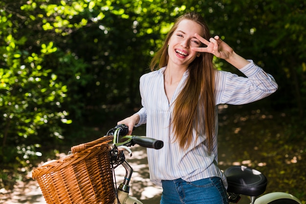 Uśmiechnięta kobieta pozuje na jej rowerze