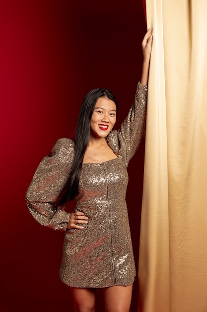 Uśmiechnięta kobieta pozuje w eleganckiej sukni od chińskiego nowego roku