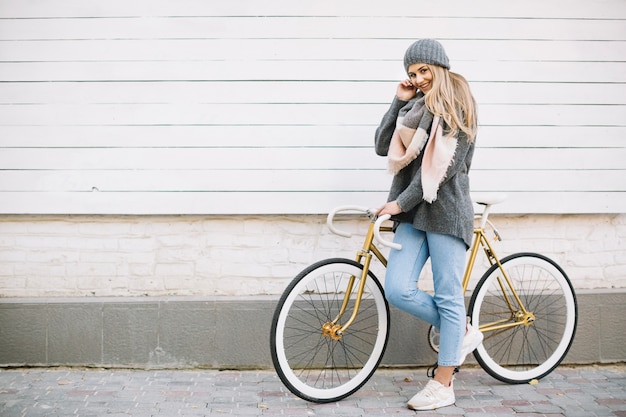 Uśmiechnięta kobieta pozuje z bicyklem