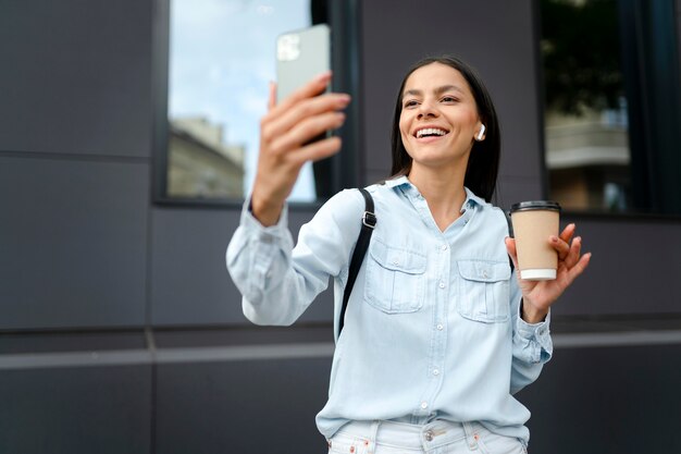 Uśmiechnięta kobieta robi selfie średnie zdjęcie