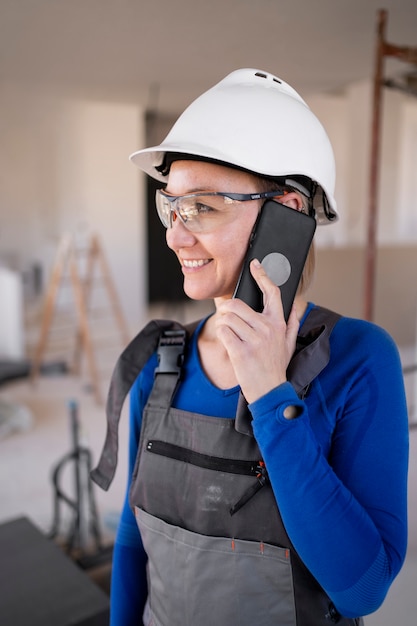 Uśmiechnięta kobieta rozmawia przez telefon średni strzał