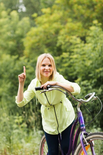 Uśmiechnięta kobieta wskazuje up na bicyklu