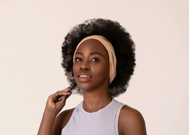 Bezpłatne zdjęcie uśmiechnięta kobieta z afro włosami pozowanie widok z boku