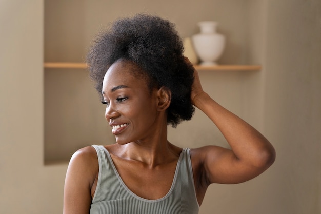 Uśmiechnięta kobieta z afro włosami w średnim ujęciu