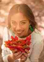 Bezpłatne zdjęcie uśmiechnięta kobieta z jesień liśćmi