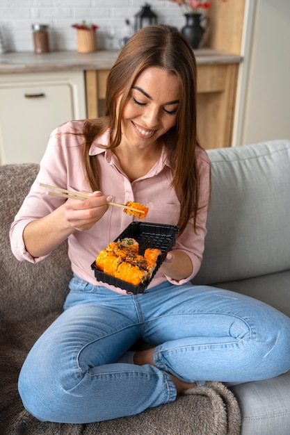 Bezpłatne zdjęcie uśmiechnięta kobieta z pełnym ujęciem sushi