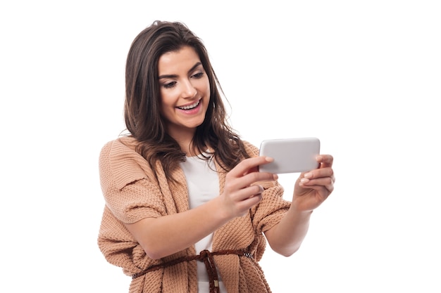 Uśmiechnięta kobieta z współczesnym telefonem komórkowym