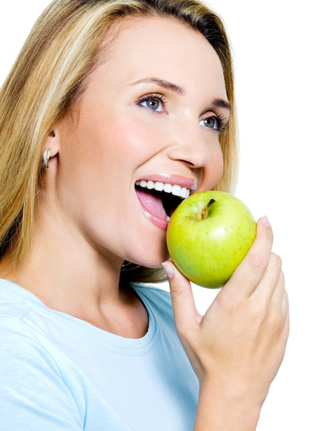 Uśmiechnięta kobieta z zielonym jabłkiem - na białym tle