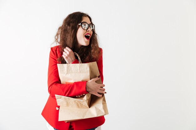 Uśmiechnięta ładna sprzedaży kobieta trzyma papierowych torba na zakupy