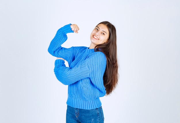 uśmiechnięta młoda dziewczyna model pokazujący jej biceps.