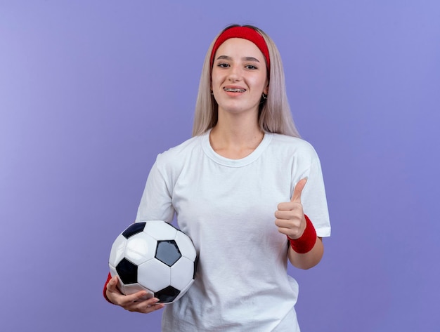 Uśmiechnięta młoda kaukaski dziewczyna sportowy z szelkami na sobie pałąk