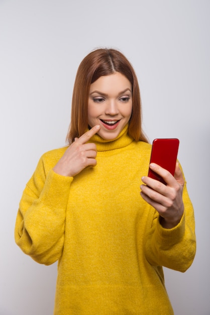 Bezpłatne zdjęcie uśmiechnięta młoda kobieta używa smartphone