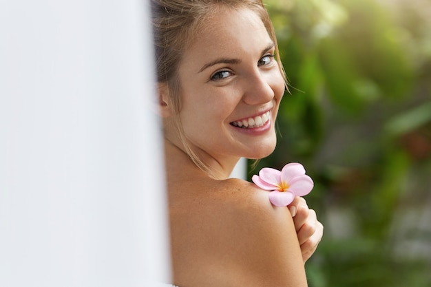 Bezpłatne zdjęcie uśmiechnięta młoda kobieta w ręczniku