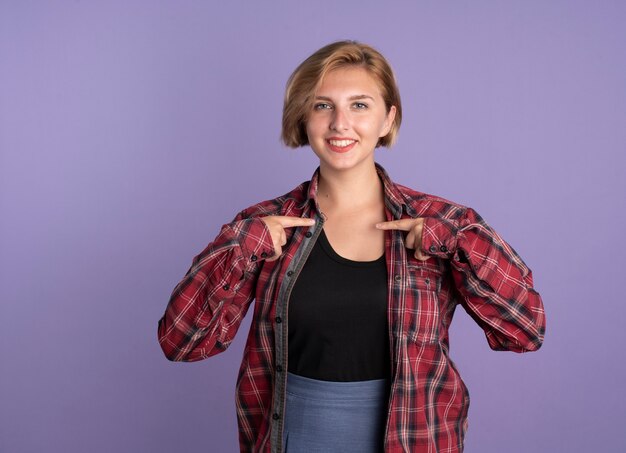 Uśmiechnięta młoda słowiańska studentka wskazuje na siebie