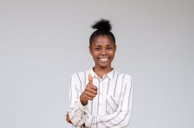 Uśmiechnięta Nigeryjska Kobieta świętująca Sukces Z Kciukami W Górę