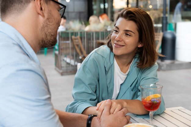 Bezpłatne zdjęcie uśmiechnięta para w widoku z boku restauracji?