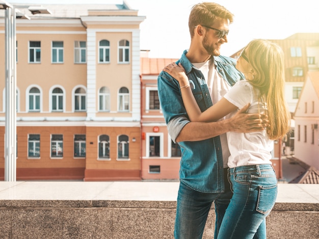 Uśmiechnięta piękna dziewczyna i jej przystojny chłopak. Kobieta w stroju casual dżinsy lato. . Patrząc na siebie