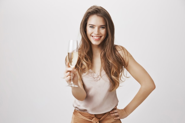 Bezpłatne zdjęcie uśmiechnięta piękna kobieta z szklanym szampanem