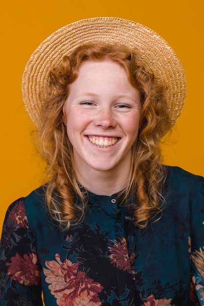 Uśmiechnięta rudzielec kobieta w studiu z jaskrawym tłem
