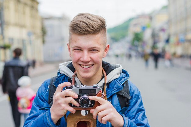 Uśmiechnięta samiec fotograf na ulicy