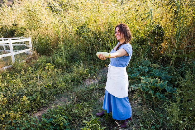 Uśmiechnięta żeńska średniorolna pokazuje gurda w ręce