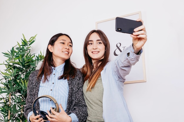 Bezpłatne zdjęcie uśmiechnięte kobiety pozuje dla selfie