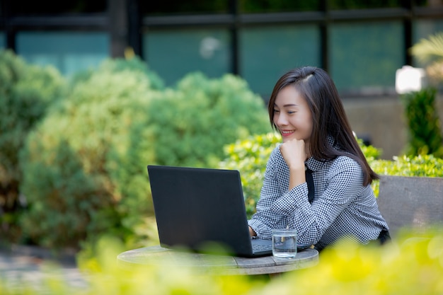 Uśmiechnięty bizneswoman pracuje na laptopie w kawiarni