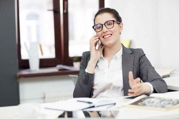 Uśmiechnięty bizneswoman z telefonem komórkowym