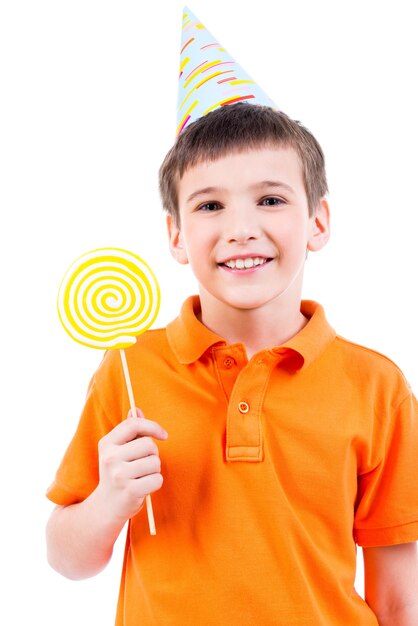 Uśmiechnięty chłopiec w pomarańczowej koszulce i kapeluszu z kolorowych cukierków - na białym tle