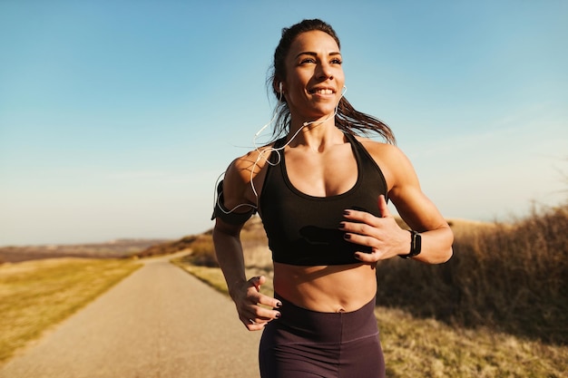 Uśmiechnięty instruktor fitness biegający podczas ćwiczeń w naturze