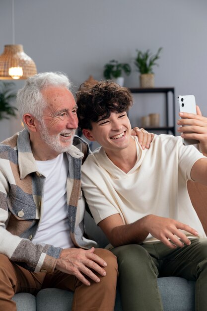 Uśmiechnięty mężczyzna i chłopiec robiący selfie średnie zdjęcie