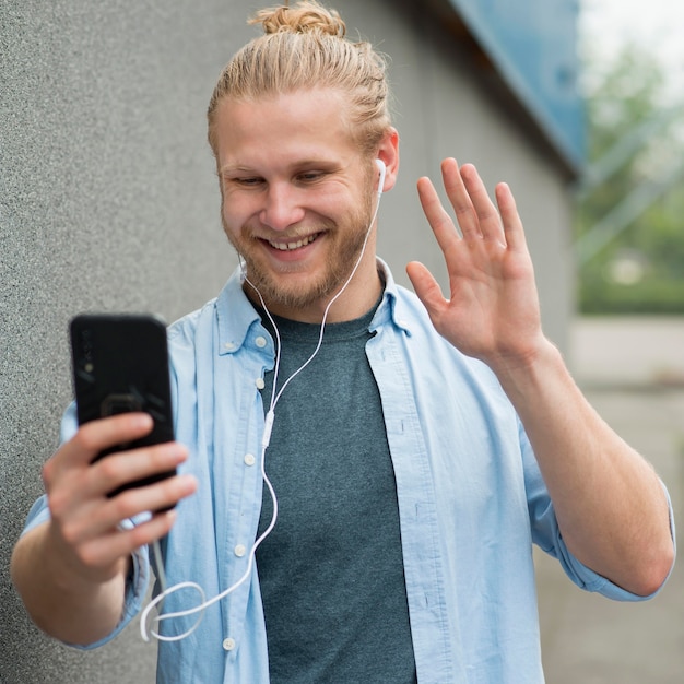 Uśmiechnięty mężczyzna rozmawia na smartfonie