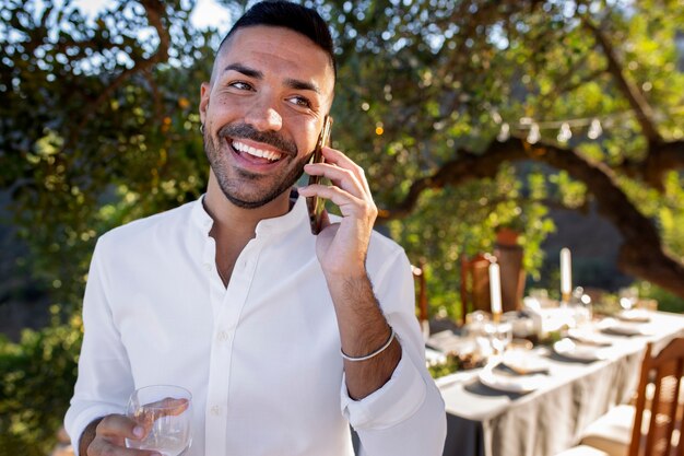 Uśmiechnięty mężczyzna rozmawia przez telefon na imprezie sylwestrowej
