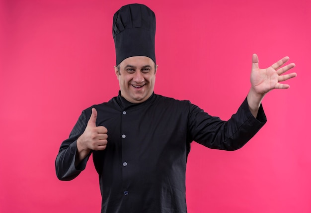 Uśmiechnięty mężczyzna w średnim wieku kucharz w mundurze szefa kuchni pokazuje różne gesty