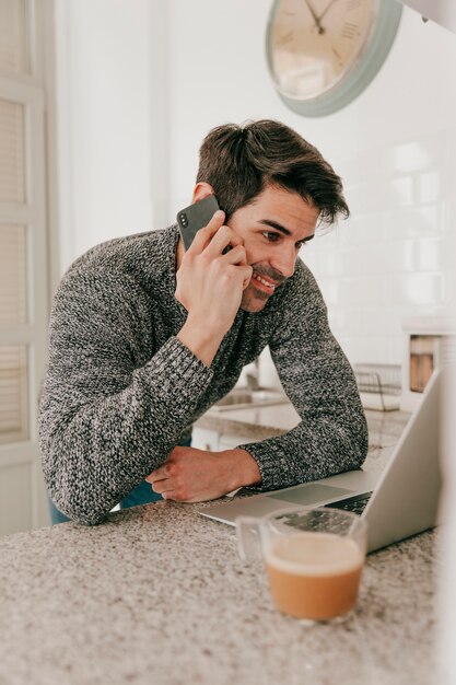 Uśmiechnięty mężczyzna z laptopem i smartphone