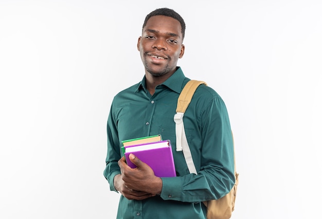Uśmiechnięty młody afroamerykański student z plecakiem trzymający książki