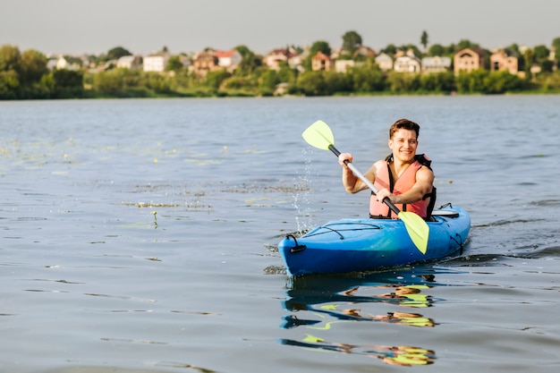 Uśmiechnięty młody człowiek cieszy się kayaking