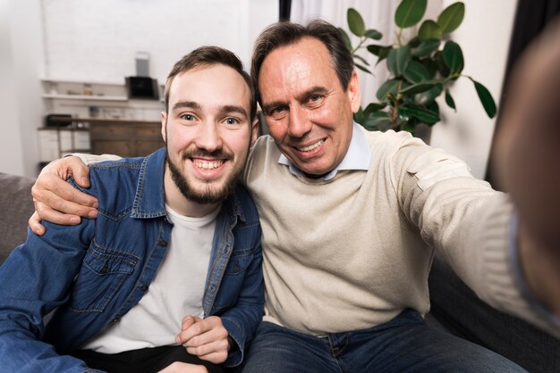 Uśmiechnięty ojciec i syn bierze selfie