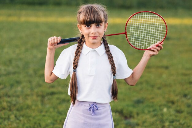 Uśmiechnięty portret dziewczyny mienia badminton