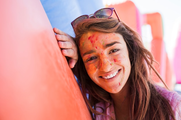 Uśmiechnięty portret młoda kobieta patrzeje kamerę z holi kolorami na twarz proszku