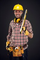 Bezpłatne zdjęcie uśmiechnięty pracownik budowlany mienia mierzenia